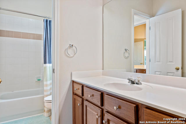 9634 Jason Bend Helotes, TX 78023 - Photo 31 of 43 a bathroom with a granite countertop sink a toilet and shower