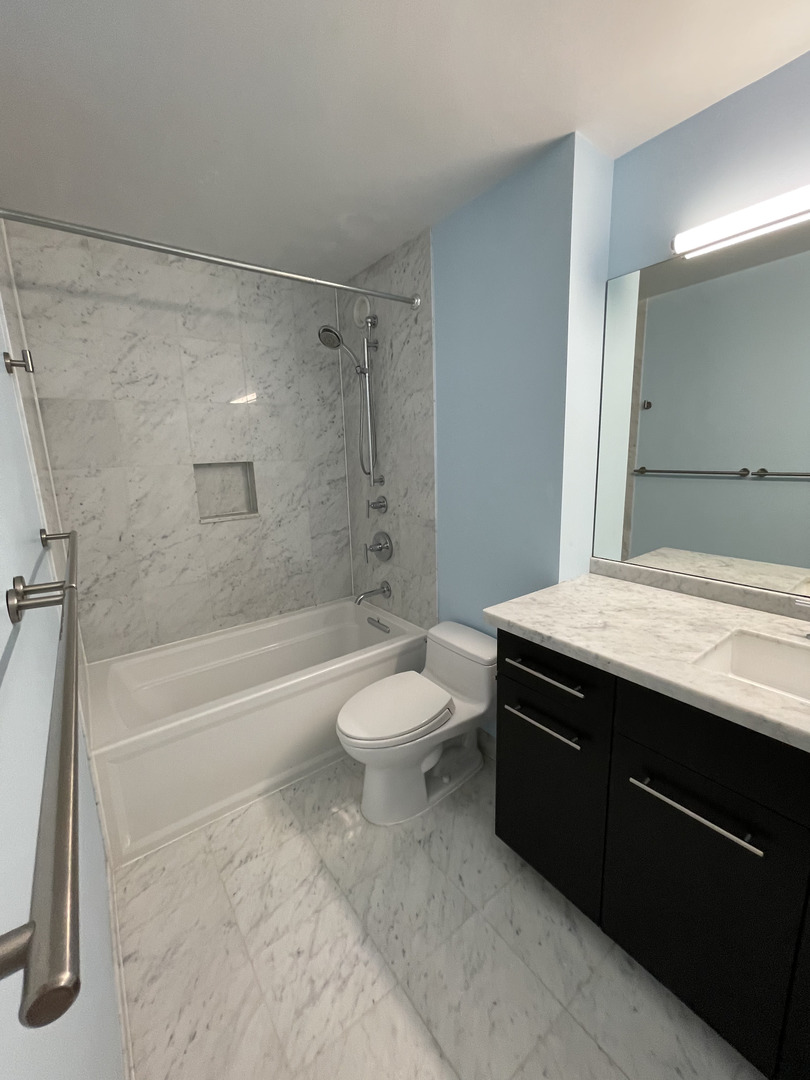 211 East Ohio Street, Unit 1013 Chicago, IL 60611 - Photo 5 of 12 a bathroom with a sink a toilet and a bathtub