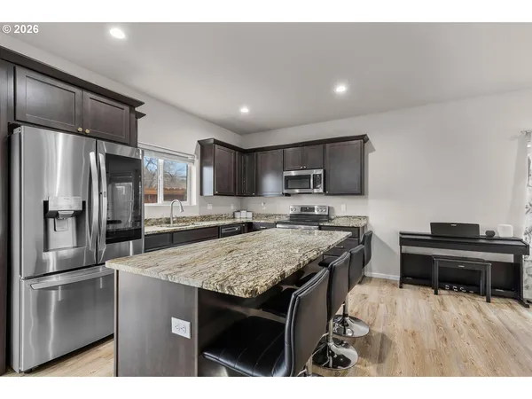 a kitchen with stainless steel appliances granite countertop a sink stove and refrigerator