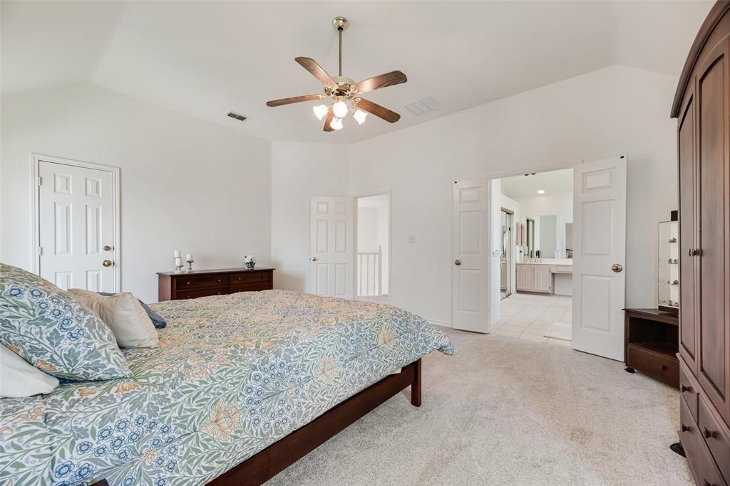 1406 West Peters Colony Road Carrollton, TX 75007 - Photo 13 of 29 a bedroom with a bed and a chandelier