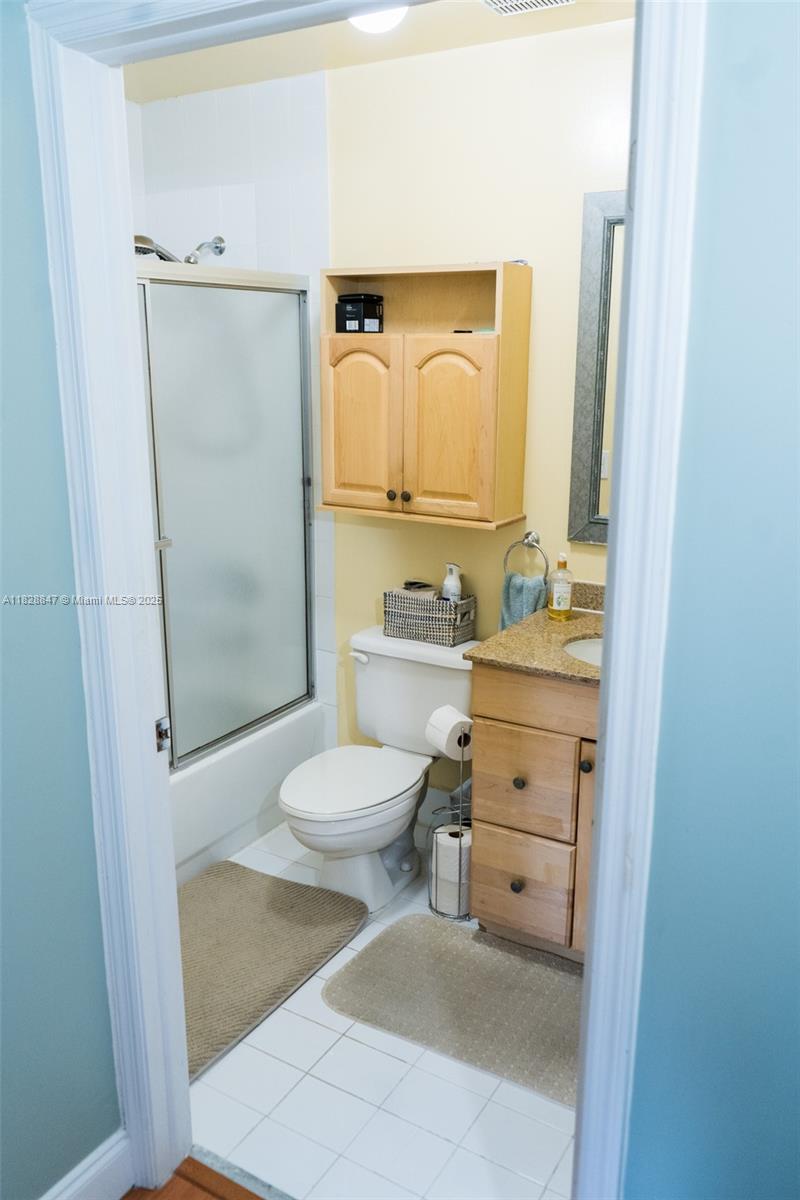13402 Southwest 153rd Street, Unit 1904 Miami, FL 33177 - Photo 13 of 26 a bathroom with a toilet sink vanity and mirror