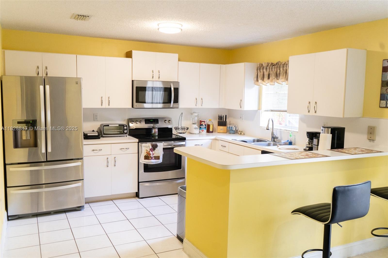13402 Southwest 153rd Street, Unit 1904 Miami, FL 33177 - Photo 7 of 26 a kitchen with a stove a sink and a refrigerator