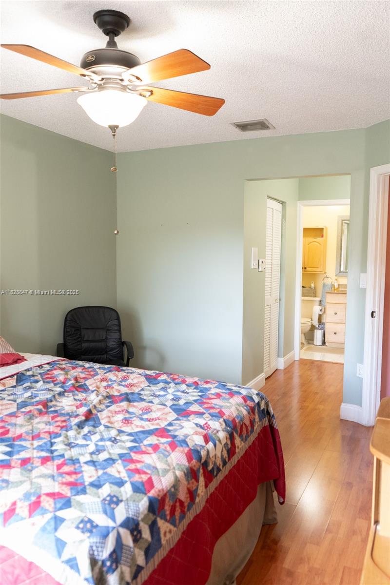 13402 Southwest 153rd Street, Unit 1904 Miami, FL 33177 - Photo 10 of 26 a bedroom with a bed and a chandelier