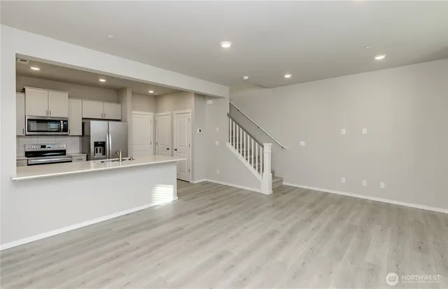 a view of kitchen with stainless steel appliances refrigerator oven and cabinets