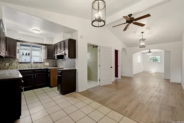 a large kitchen with a wooden floor and cabinets