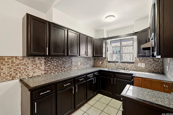 a kitchen with stainless steel appliances granite countertop a sink stove and cabinets