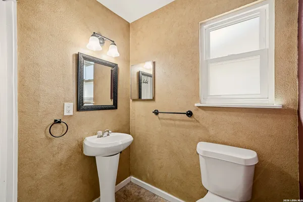a bathroom with a toilet sink and mirror