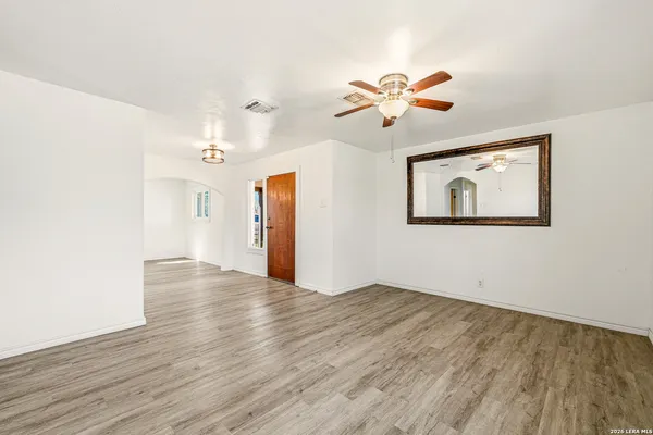 a view of empty room with wooden floor