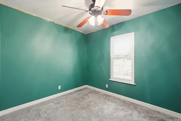 a view of a room that has a fan and window