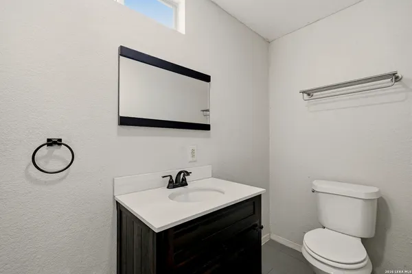 a bathroom with a toilet sink and mirror