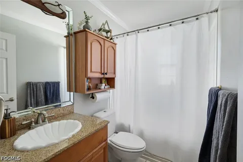a bathroom with a granite countertop sink toilet and shower