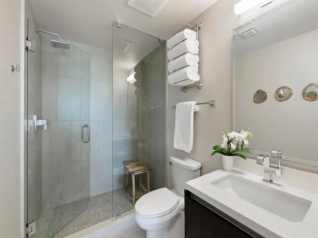 a bathroom with a sink toilet a mirror and shower