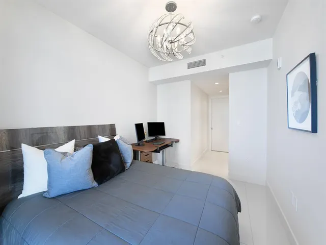 a bedroom with a bed and a chandelier