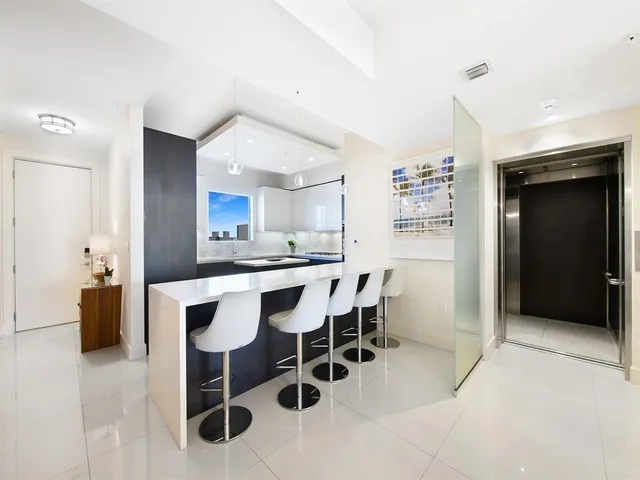 a kitchen with a dining table chairs and refrigerator