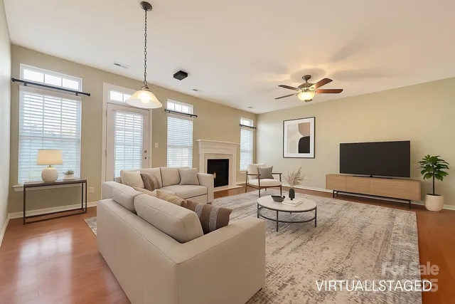 a living room with fireplace furniture and a large window