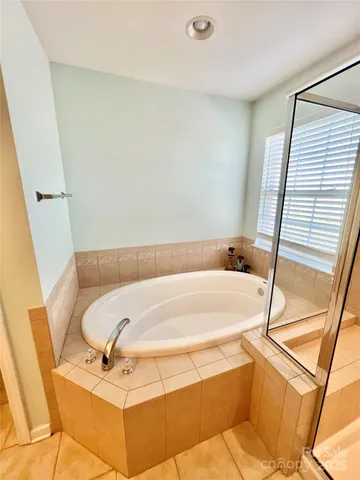 a spacious bathroom with a bathtub sink and mirror