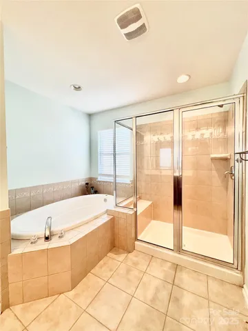 a spacious bathroom with a bathtub sink and mirror