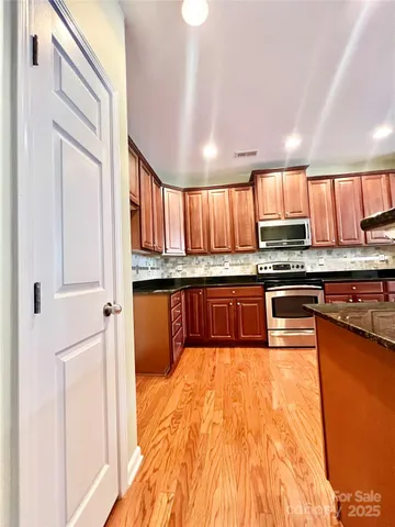 a view of a kitchen with a stove and a wooden floor