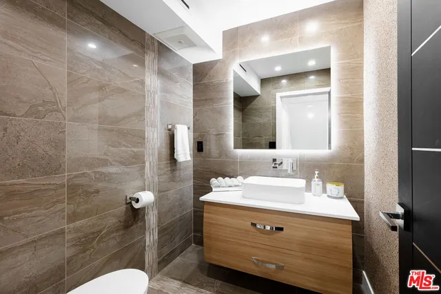 a bathroom with a sink a toilet and mirror