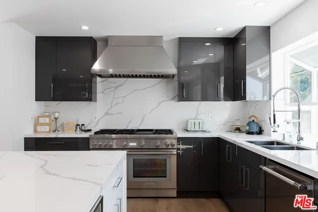 a kitchen with stainless steel appliances a sink dishwasher stove and cabinets