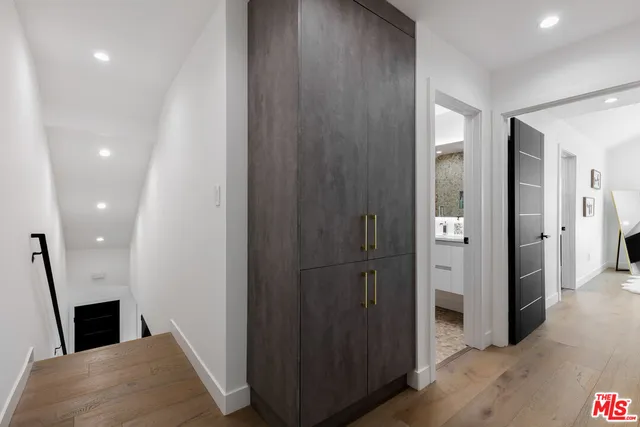 a view of a hallway with wooden floor and staircase