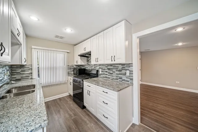 a kitchen with stainless steel appliances granite countertop a stove and a refrigerator
