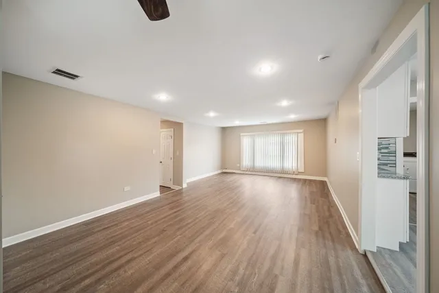 a view of an empty room with wooden floor