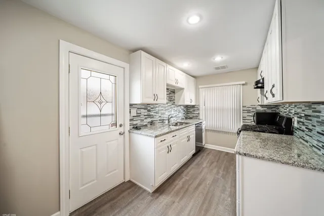 a kitchen with granite countertop a sink stove and refrigerator