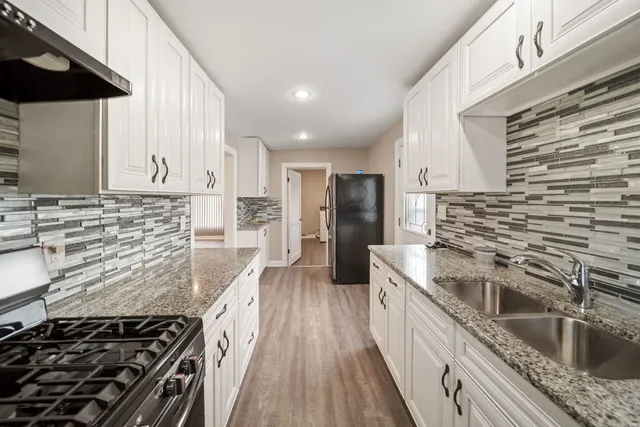 a kitchen with stainless steel appliances granite countertop a stove a sink and a refrigerator