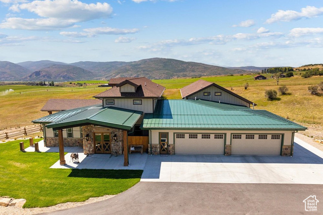 6117 North Rocky Ridge Road Peoa, UT 84061 - Photo 6 of 83 View of front of house featuring a garage, a mountain view, a front yard, and a rural view