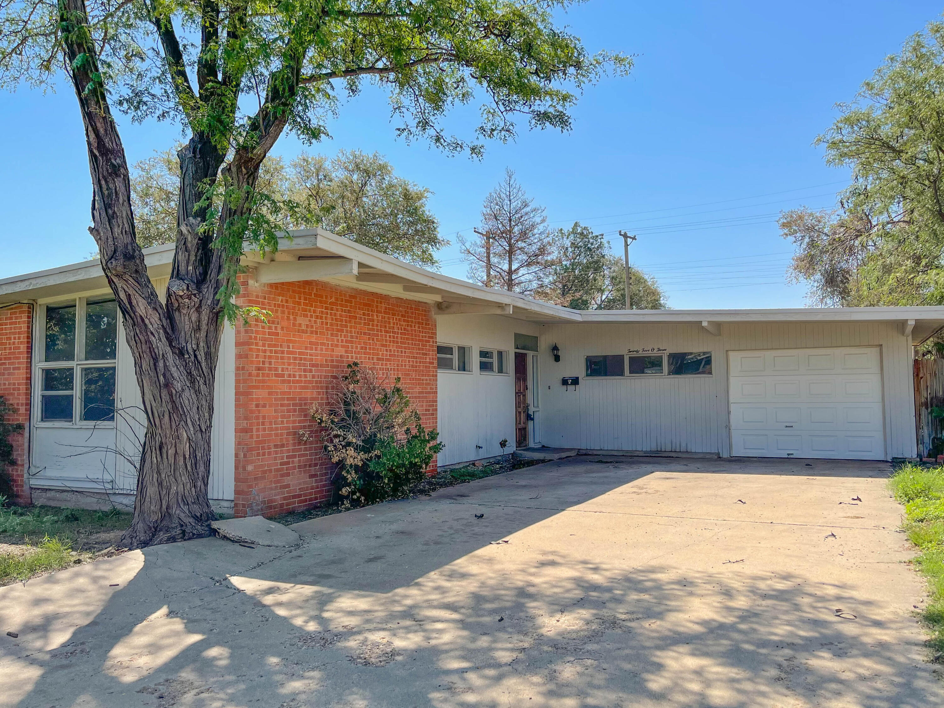 a front view of house with yard and trees around