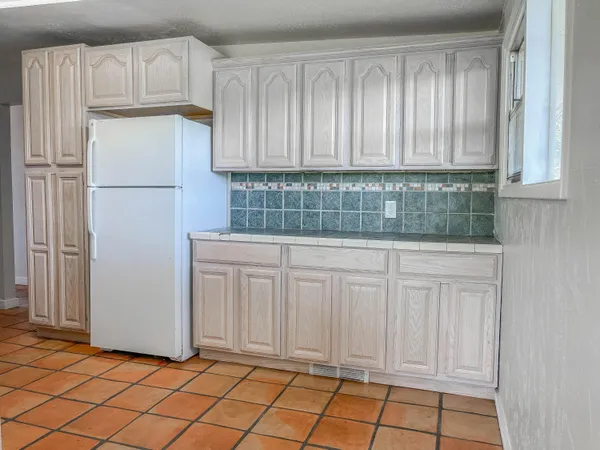 a view of a kitchen with white cabinets