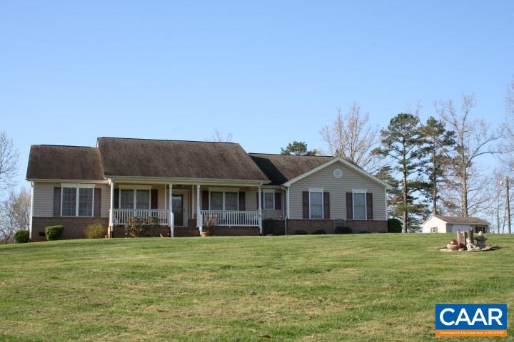 a front view of a house with a garden and lake view