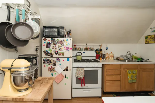 a white kitchen with a refrigerator and a stove