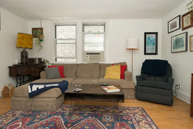a living room with furniture a rug and a window