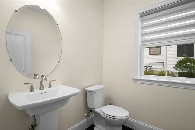 a bathroom with a toilet a sink and a mirror