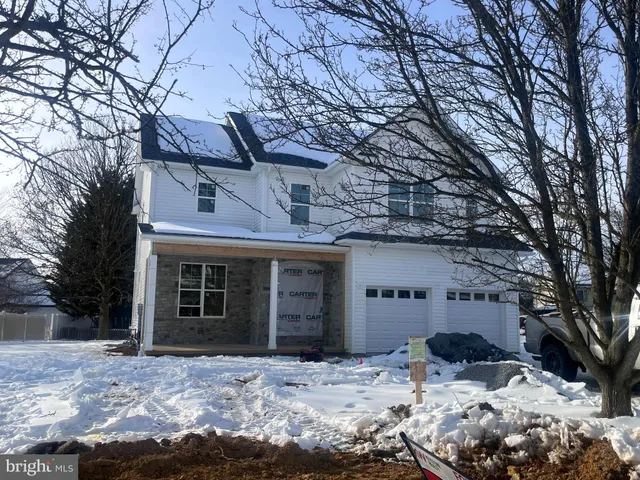 a view of a house with a yard covered in snow