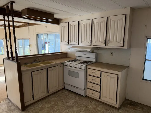 a kitchen with white cabinets and a stove top oven
