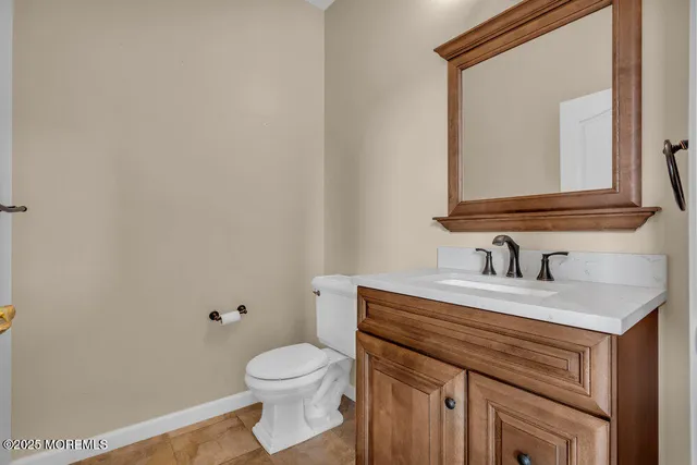 a bathroom with a granite countertop toilet sink and mirror