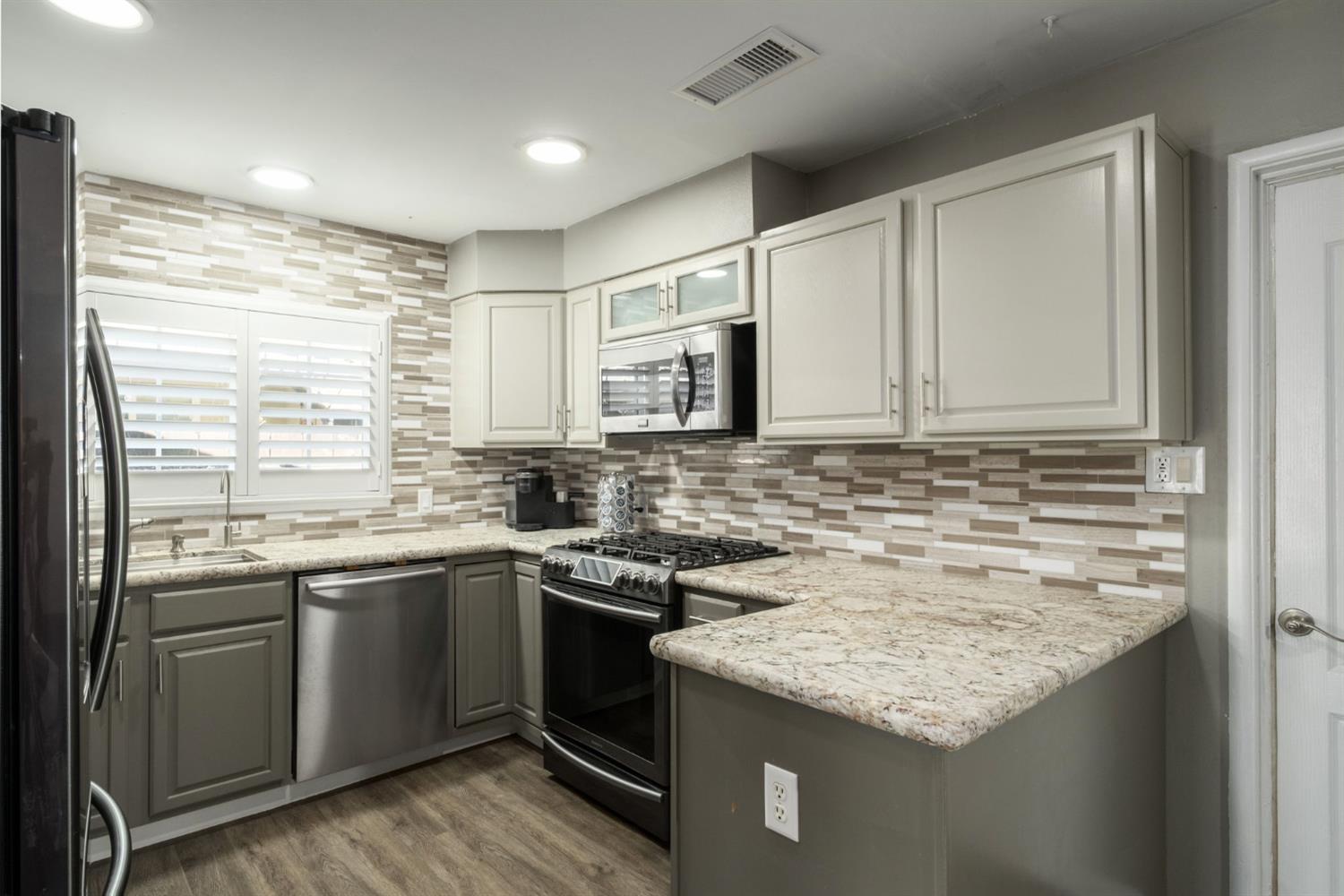 2604 Harvard Avenue Clovis, CA 93612 - Photo 14 of 28 a kitchen with stainless steel appliances granite countertop a sink and stove top oven