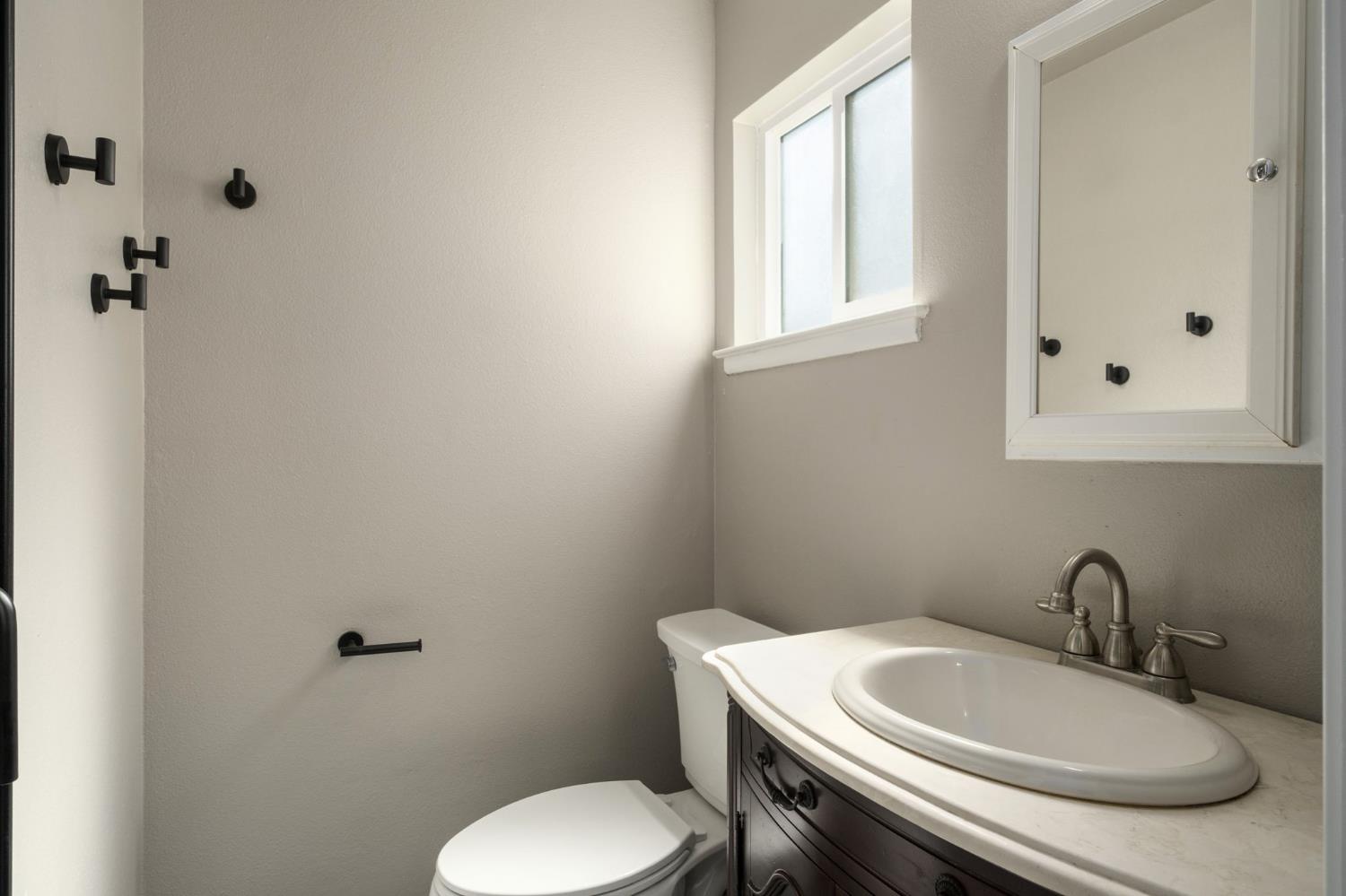 2604 Harvard Avenue Clovis, CA 93612 - Photo 17 of 28 a bathroom with a toilet sink and mirror
