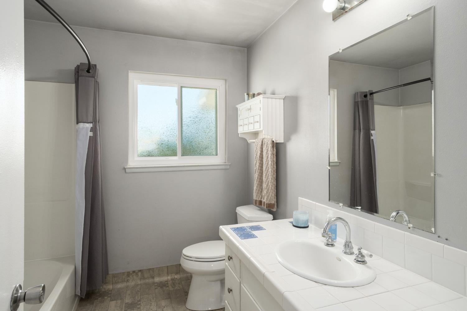 2604 Harvard Avenue Clovis, CA 93612 - Photo 20 of 28 a bathroom with a toilet sink and mirror