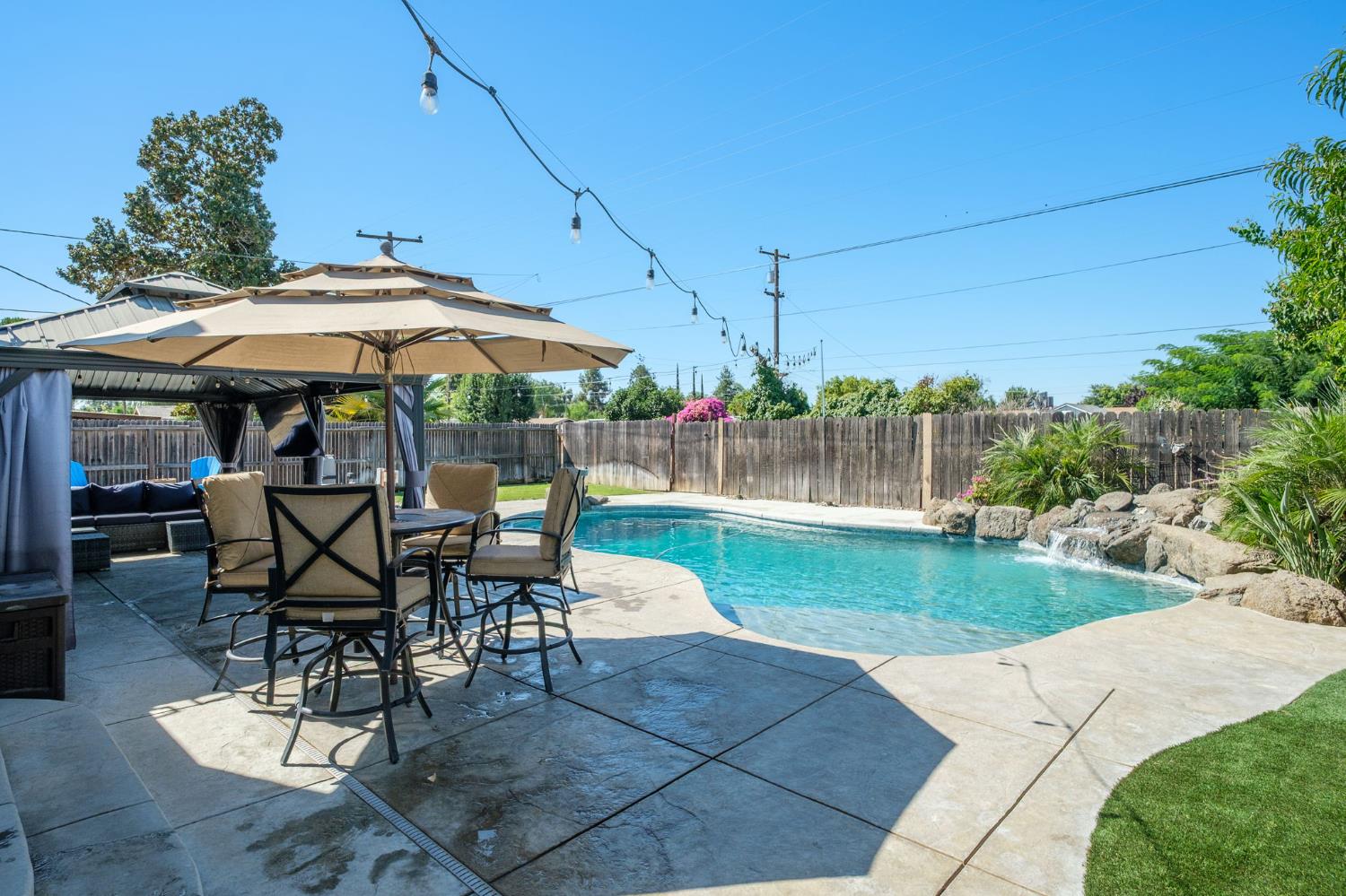 2604 Harvard Avenue Clovis, CA 93612 - Photo 22 of 28 a view of a patio with table and chairs under an umbrella