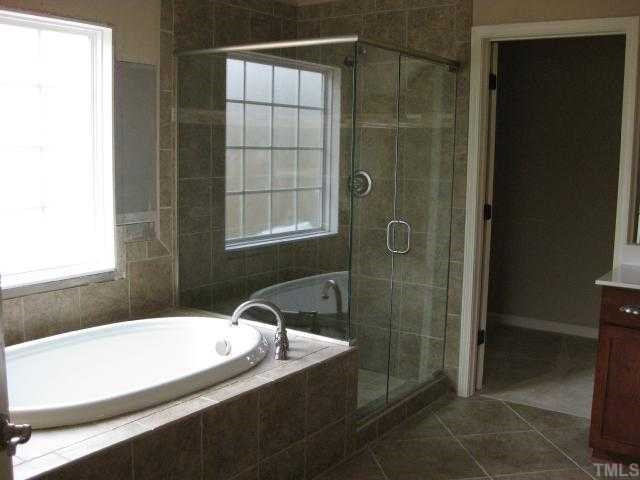 2105 Lower Lake Road Wake Forest, NC 27587 - Photo 9 of 12 Fantastic master bath with garden tub + separate shower with plenty of room to move around! Dual vanities, water closet, vaulted ceiling & huge walk-in closet! Master Bath/Spa