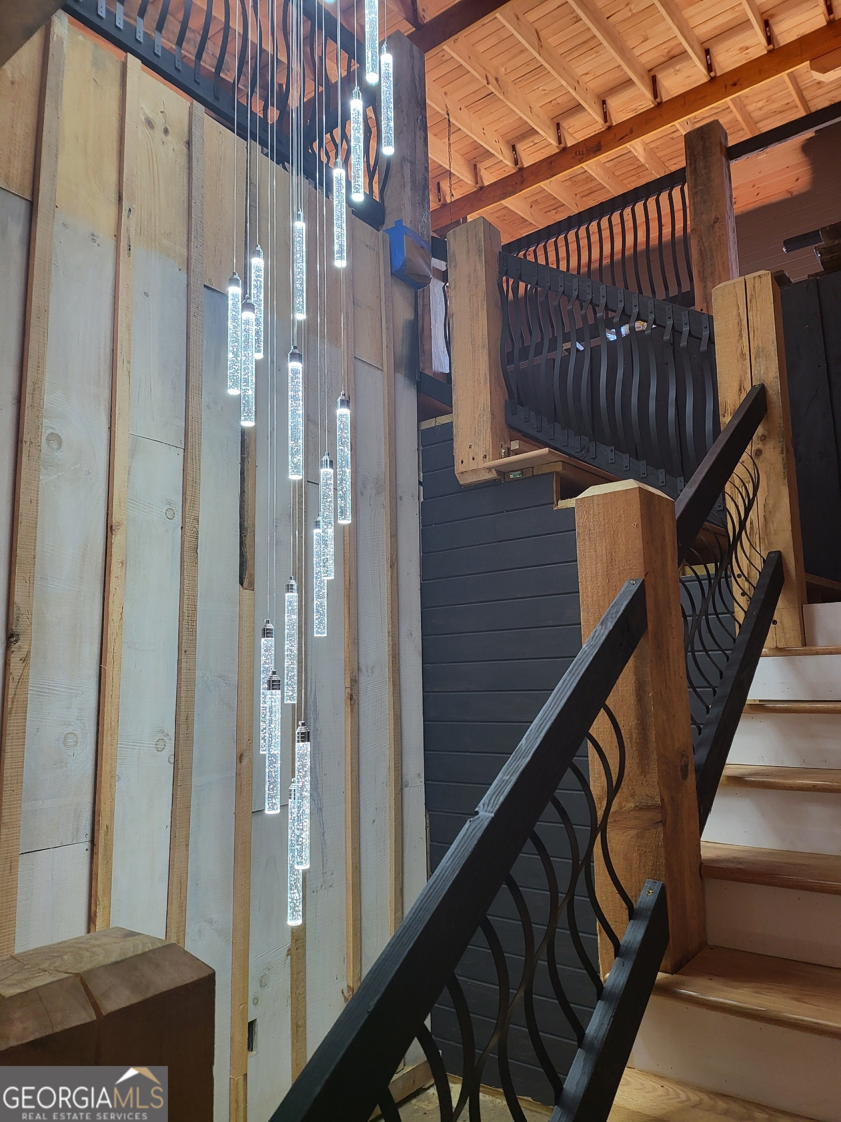 389 Fort Mountain Road Blairsville, GA 30512 - Photo 27 of 30 a view of staircase with railing and a chandelier