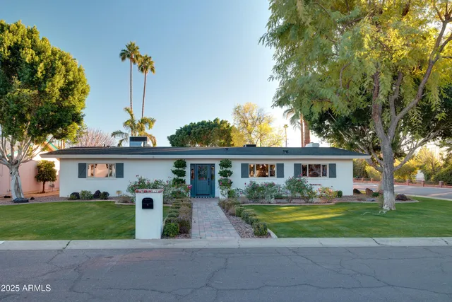 a front view of a house with a garden and plants