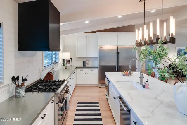 a kitchen with stainless steel appliances a sink stove and refrigerator