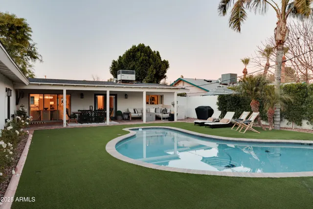 a view of a house with swimming pool and a yard