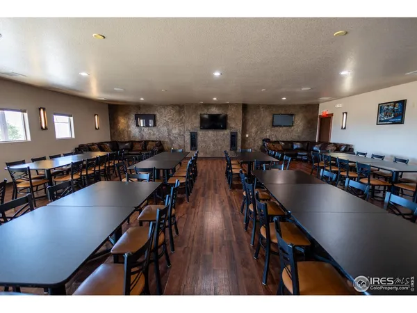 a kitchen with stainless steel appliances a sink a stove a refrigerator a center island and wooden floor