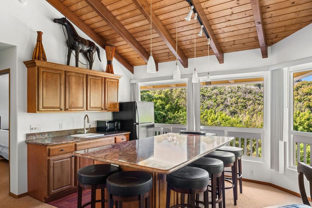 1444 West Kuiaha Road Haiku, HI 96708 - Photo 11 of 30 a kitchen with stainless steel appliances granite countertop a stove a refrigerator a sink a stove and white cabinets with wooden floor